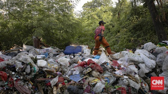 Petugas melakukan pembersihan tumpukan sampah rumah tangga yang menutupi sebagian akses Jalan Gang Swadaya, Kelurahan Cakung Barat, Kecamatan Cakung, Jakarta Timur. Kondisi tersebut mengganggu aktivitas warga di sekitar Rusun Albo akibat bau menyenga
