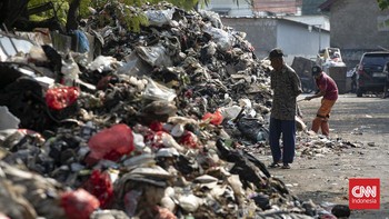 Petugas melakukan pembersihan tumpukan sampah rumah tangga yang menutupi sebagian akses Jalan Gang Swadaya, Kelurahan Cakung Barat, Kecamatan Cakung, Jakarta Timur. Kondisi tersebut mengganggu aktivitas warga di sekitar Rusun Albo akibat bau menyenga