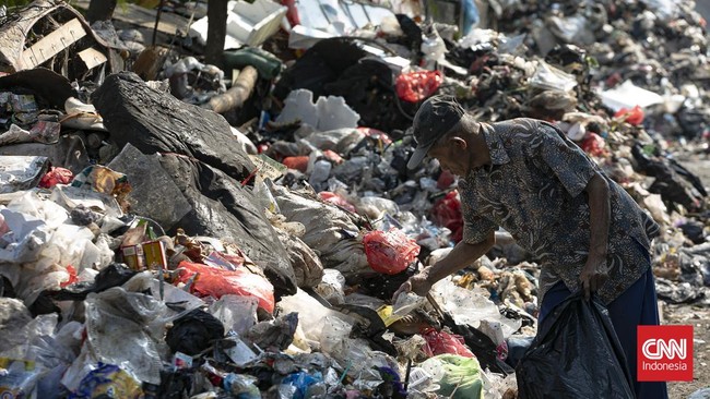 Petugas melakukan pembersihan tumpukan sampah rumah tangga yang menutupi sebagian akses Jalan Gang Swadaya, Kelurahan Cakung Barat, Kecamatan Cakung, Jakarta Timur. Kondisi tersebut mengganggu aktivitas warga di sekitar Rusun Albo akibat bau menyenga