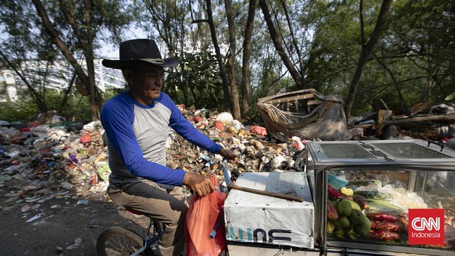 Petugas melakukan pembersihan tumpukan sampah rumah tangga yang menutupi sebagian akses Jalan Gang Swadaya, Kelurahan Cakung Barat, Kecamatan Cakung, Jakarta Timur. Kondisi tersebut mengganggu aktivitas warga di sekitar Rusun Albo akibat bau menyenga