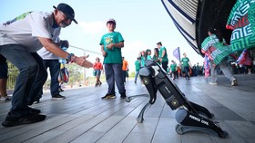 Para suporter berinteraksi dengan anjing robot dari Fuerza Civil yang berpatroli di luar stadion sebelum pertandingan babak 32 besar Piala Dunia 2026.