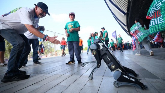 Para suporter berinteraksi dengan anjing robot dari Fuerza Civil yang berpatroli di luar stadion sebelum pertandingan babak 32 besar Piala Dunia 2026.