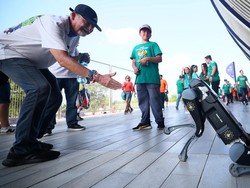 Para suporter berinteraksi dengan anjing robot dari Fuerza Civil yang berpatroli di luar stadion sebelum pertandingan babak 32 besar Piala Dunia 2026.