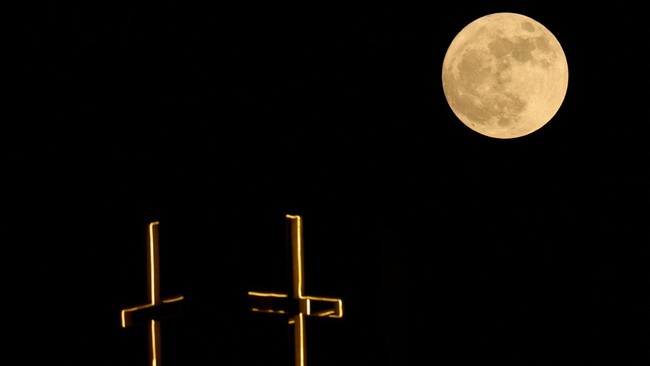 Strawberry Moon terbit di atas salib Gereja Santo Antonius, di atas ibu kota Kairo, Mesir, pada 29 Juni 2026. (REUTERS/Amr Abdallah Dalsh)
