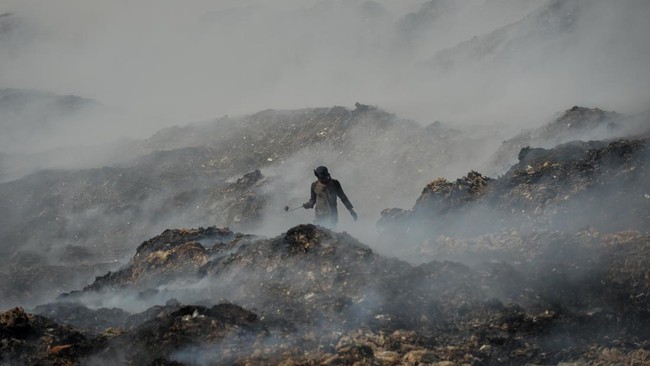 Pemulung memilah sampah pada tumpukan sampah yang terbakar di Tempat Pembuangan Akhir (TPA) Jatiwaringin, Kabupaten Tangerang, Banten, Rabu (1/7/2026). Badan Nasional Penanggulangan Bencana (BNPB) menyatakan area yang terdampak kebakaran TPA Jatiwari