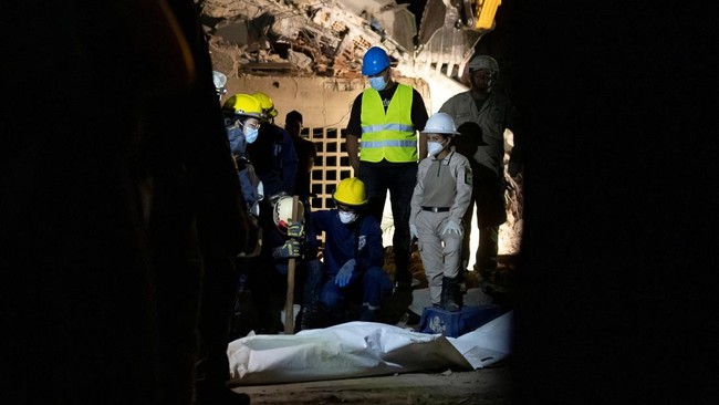 Members of Caracas firefighters react after the recovery of a dead body in a collapsed building in La Guaira, on June 27, 2026. The death toll from two powerful earthquakes that devastated Venezuela earlier this week rose to 920 on June 26, National