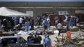 EDITORS NOTE: Graphic content / Forensic experts carry out body identification work on corpses laid out on the ground near coffins at a makeshift morgue in the port of La Guaira, La Guaira State, Venezuela on June 29, 2026, days after twin earthquake