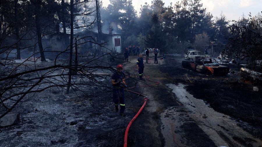 Petugas pemadam kebakaran berupaya memadamkan kebakaran rimba di dekat sebuah rumah nan terbakar di dekat desa Liti, Thessaloniki, Yunani, 30 Juni 2026.