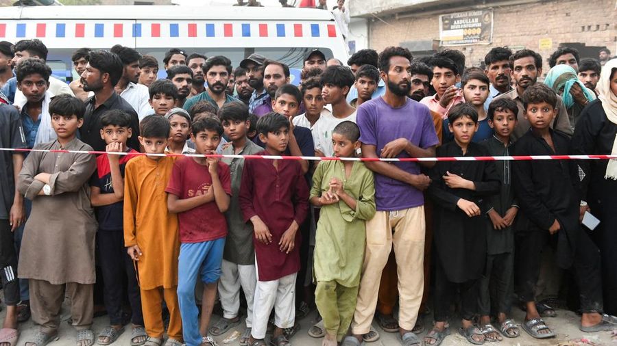 Warga berkumpul di letak tempat anak-anak dilaporkan meninggal setelah genting pusat pengarahan belajar runtuh, di Lahore, Pakistan, 30 Juni 2026.