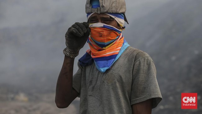 Aktivitas warga terdampak asap kebakaran Tempat Pembuangan Akhir (TPA) Jatiwaringin di Rajeg, Kabupaten Tangerang, Banten, Kamis (02/07/2026). (CNN Indonesia/Adhi Wicaksono)