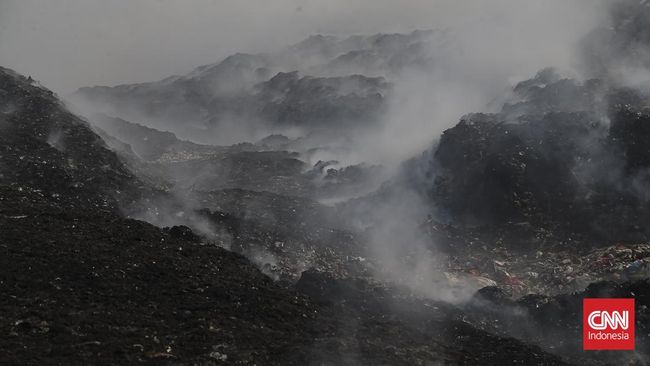 Petugas pemadam kebakaran berusaha memadamkan api di Tempat Pembuangan Akhir (TPA) Jatiwaringin, Kabupaten Tangerang, Banten, Kamis (02/07/2026).  (CNN Indonesia/Adhi Wicaksono)