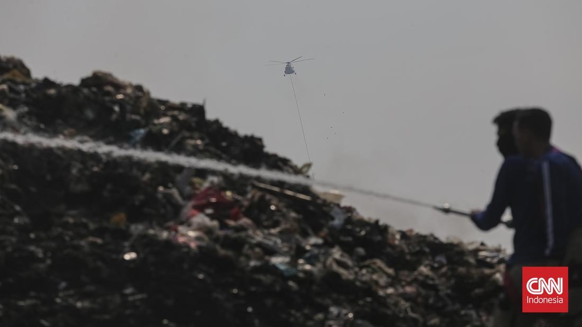 Petugas pemadam kebakaran berusaha memadamkan api di Tempat Pembuangan Akhir (TPA) Jatiwaringin, Kabupaten Tangerang, Banten, Kamis (02/07/2026).  (CNN Indonesia/Adhi Wicaksono)
