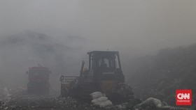 Petugas pemadam kebakaran berusaha memadamkan api di Tempat Pembuangan Akhir (TPA) Jatiwaringin, Kabupaten Tangerang, Banten.