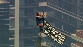 Two people display a banner atop the Empire State Building in the Manhattan borough of New York, U.S., July 1, 2026 in a still image from video.  ABC Affiliate WABC/Handout via REUTERS.  NO RESALES. NO ARCHIVES. THIS IMAGE HAS BEEN SUPPLIED BY A THIR
