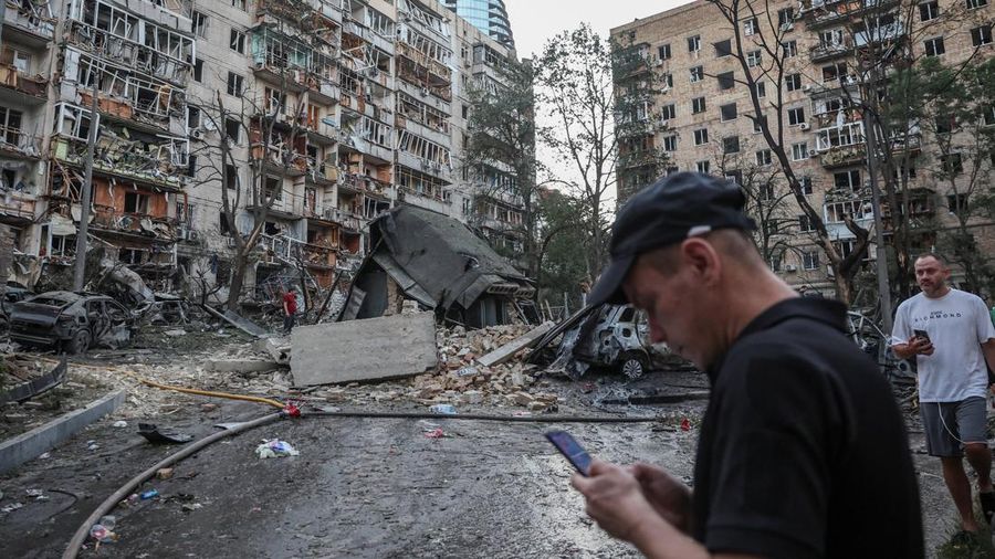 Orang-orang berkumpul di dekat gedung nan rusak akibat serangan rudal dan pesawat tak berawak Rusia semalam, di tengah serangan Rusia terhadap Ukraina, di Kyiv, Ukraina, 2 Juli 2026.