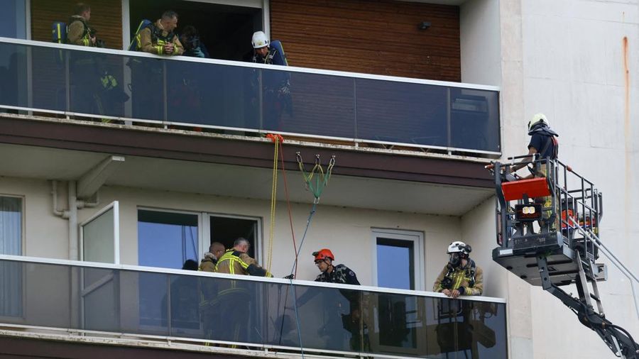 Para petugas penyelamat bekerja di letak kebakaran di sebuah gedung perumahan di Antwerp, Belgia, 1 Juli 2026. (REUTERS/Yves Herman)