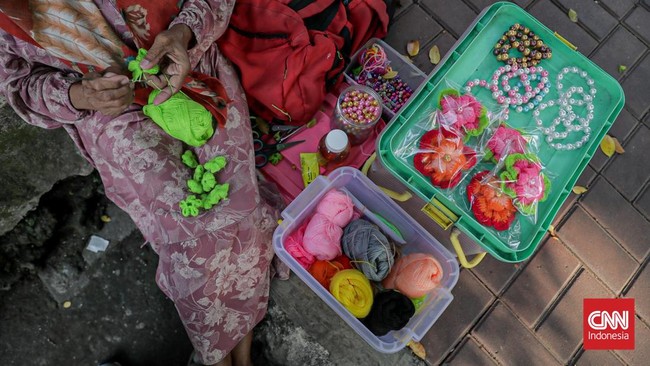 Lansia Jeminem (62) masih produktif menjajakan rajutan karyanya. Dahulu di tepi Stasiun Depok, kini di Stasiun Duren Kalibata.