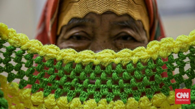 Lansia Jeminem (62) masih produktif menjajakan rajutan karyanya. Dahulu di tepi Stasiun Depok, kini di Stasiun Duren Kalibata.