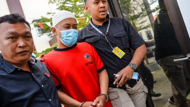 Petugas menggiring tersangka kasus dugaan penyekapan dan penganiayaan berat Taufik Hidayat untuk menjalani rekonstruksi.