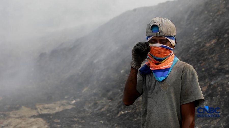 Seorang terlihat mengumpulkan sisa-sisa besi jejak dari gunungan sampah nan sebagian telah gosong terbakar ditengah kebakaran melanda TPA Jatiwaringin, Kabupaten Tangerang, Banten, Kamis, (2/7/2026).