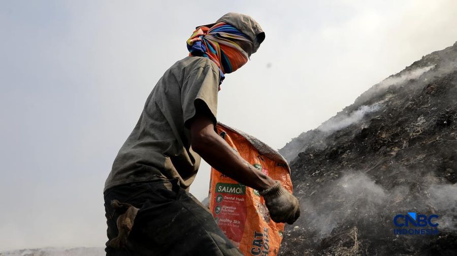 Seorang terlihat mengumpulkan sisa-sisa besi jejak dari gunungan sampah nan sebagian telah gosong terbakar ditengah kebakaran melanda TPA Jatiwaringin, Kabupaten Tangerang, Banten, Kamis, (2/7/2026).