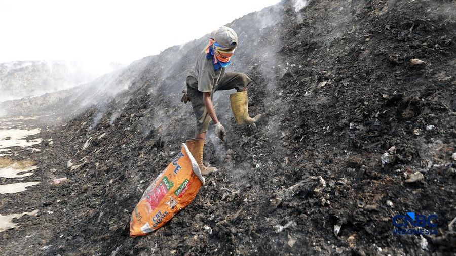 Seorang terlihat mengumpulkan sisa-sisa besi jejak dari gunungan sampah nan sebagian telah gosong terbakar ditengah kebakaran melanda TPA Jatiwaringin, Kabupaten Tangerang, Banten, Kamis, (2/7/2026).