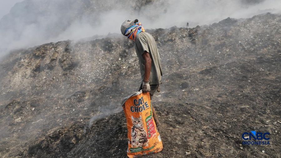 Seorang terlihat mengumpulkan sisa-sisa besi jejak dari gunungan sampah nan sebagian telah gosong terbakar ditengah kebakaran melanda TPA Jatiwaringin, Kabupaten Tangerang, Banten, Kamis, (2/7/2026).