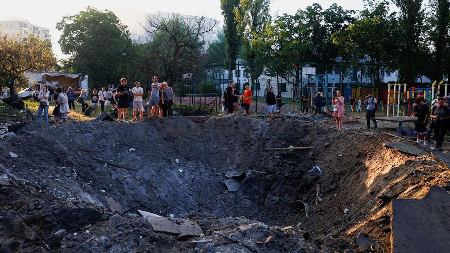 Warga berdiri di samping kawah nan terbentuk di letak tersebut akibat serangan rudal dan pesawat tak berawak Rusia semalaman, di tengah serangan Rusia terhadap Ukraina, di Kyiv, Ukraina, 2 Juli 2026.