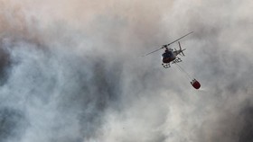 A helicopter conducts firefighting operations as wildfire burns in Pouzols-Minervois near Narbonne, France, July 2, 2026. REUTERS/Alexandre Dimou