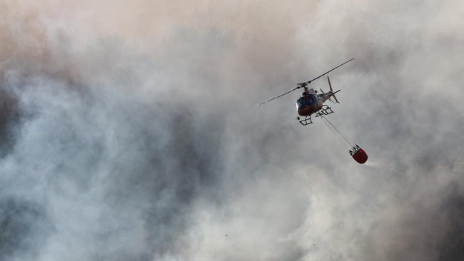 A helicopter conducts firefighting operations as wildfire burns in Pouzols-Minervois near Narbonne, France, July 2, 2026. REUTERS/Alexandre Dimou