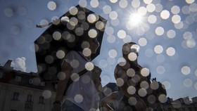 People shelter from the sun under umbrellas as they walk on the Royal Castle Square in Warsaw's Old Town as thermometers show record temperatures during a heatwave that has reached Poland on 28 June 2026 (Photo by Wojtek RADWANSKI / AFP)