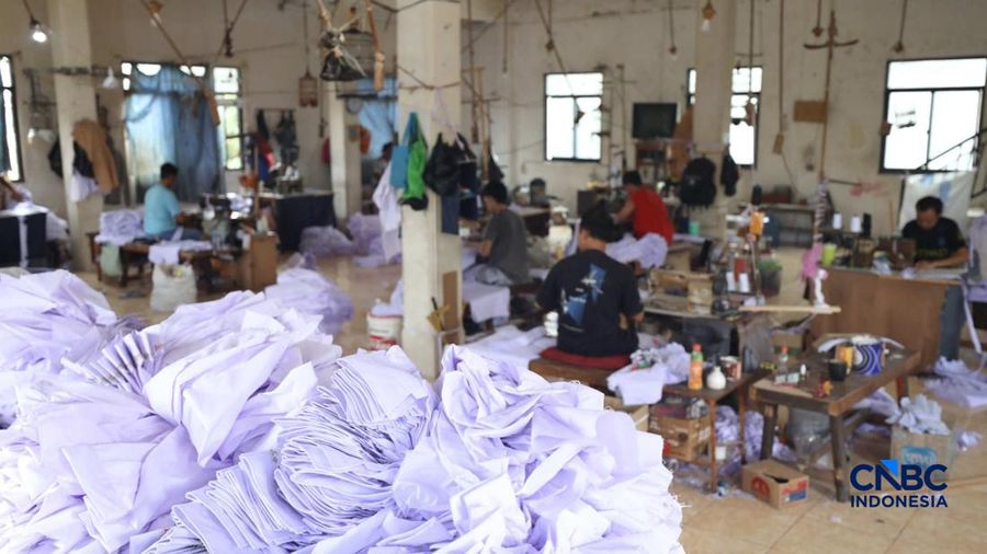 Pekerja menyelesaikan produksi pakain sekolah di konveksi rumahan area Jakarta, Jumat (3/7/2026).
