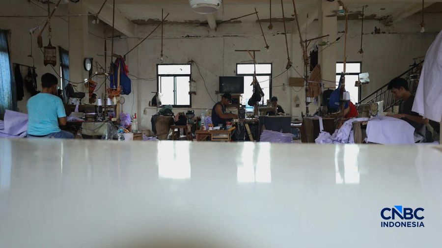 Pekerja menyelesaikan produksi pakain sekolah di konveksi rumahan area Jakarta, Jumat (3/7/2026).