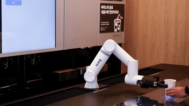 A robot arm serves coffee at an unmanned cafe in Seoul, South Korea, June 19, 2026. REUTERS/Kim Soo-hyeon