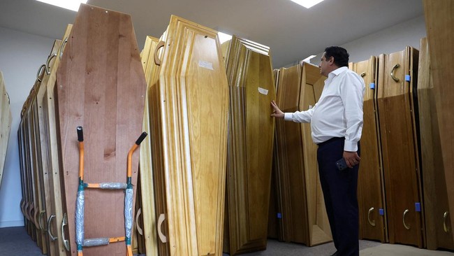 An employee at Orly International Funeral Home checks coffins as the facility reaches full capacity amid a heatwave that has caused about 1,000 excess deaths in France, in Orly, France, June 29, 2026. REUTERS/Alice Sacco