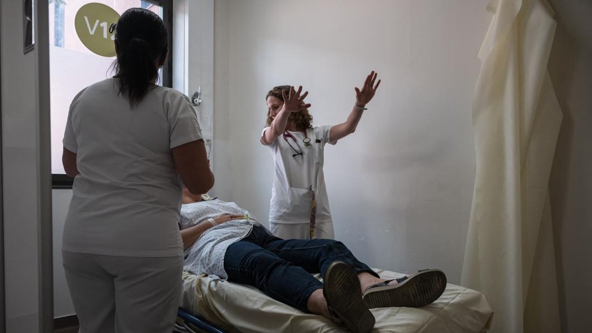 A doctor evaluates a patient suffering from heat exposure at Purpan Hospital as France experiences a heatwave, in Toulouse on June 23, 2026. France experienced its hottest day since measurements began on June 23, 2026 the national weather agency said