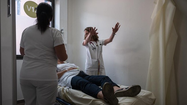 A doctor evaluates a patient suffering from heat exposure at Purpan Hospital as France experiences a heatwave, in Toulouse on June 23, 2026. France experienced its hottest day since measurements began on June 23, 2026 the national weather agency said