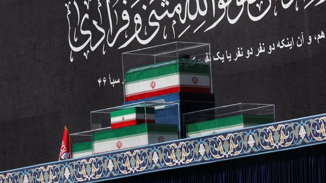 The coffins of Iran's late Supreme Leader Ayatollah Ali Khamenei and his family members in the colours of Iranian flags on the stage, as people gather for a public farewell ceremony to pay their respects to late Supreme Leader Ayatollah Ali Khamenei,