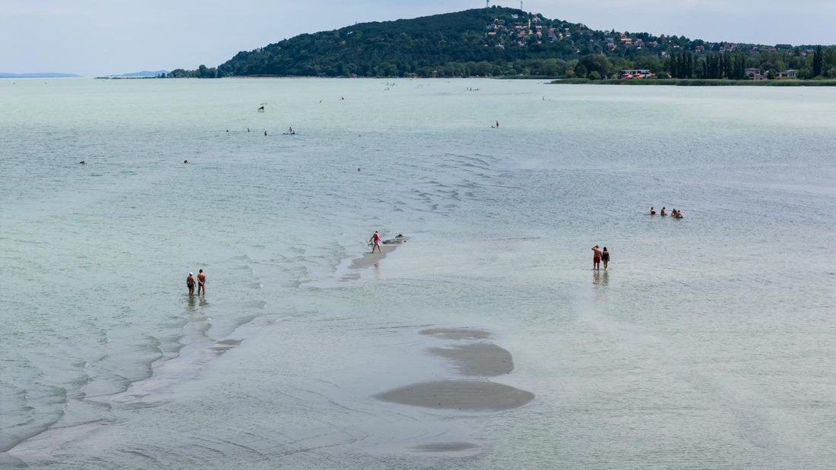 A drone view shows people walking on an exposed sandbank locally known as