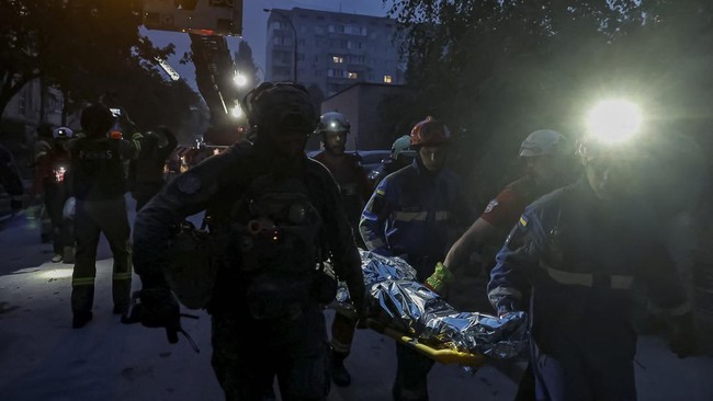 Emergency workers carry a wounded person at the site of an apartment building which was heavily damaged during Russian missile and drone strikes, amid Russia's attack on Ukraine, in Kyiv, Ukraine July 6, 2026. REUTERS/Thomas Peter