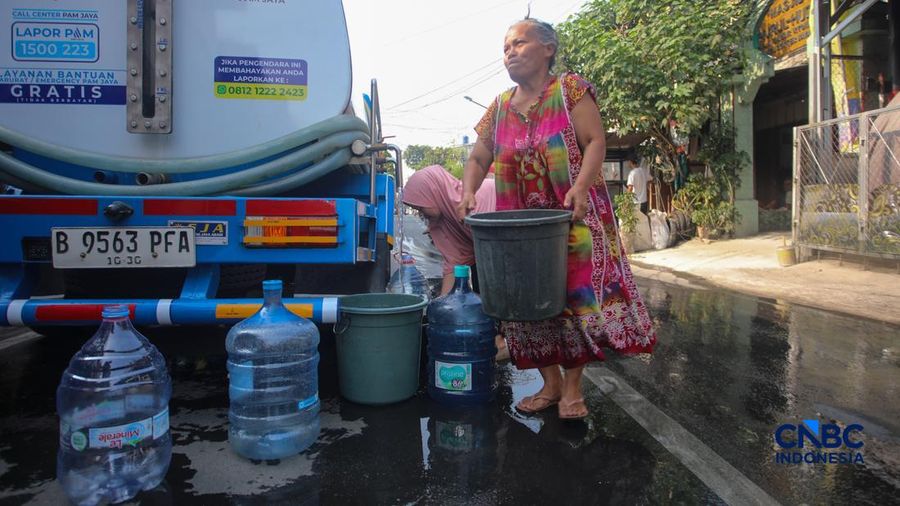Warga mengambil air bersih dari mobil jasa support air bersih di Jalan H Mawar, Sunter Jaya, Tanjung Priok, Jakarta Utara, Senin (6/7/2026).