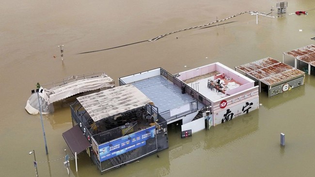 Flooded shops along a submerged riverside walk are seen by the overflowing Yongjiang river in Nanning, in Chinaís southern Guangxi region on July 7, 2026. The death toll from devastating storms in parts of China rose to 15 on July 7, with hundreds m