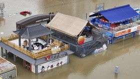 Flooded shops along a submerged riverside walk are seen by the overflowing Yongjiang river in Nanning, in Chinaís southern Guangxi region on July 7, 2026. The death toll from devastating storms in parts of China rose to 15 on July 7, with hundreds m