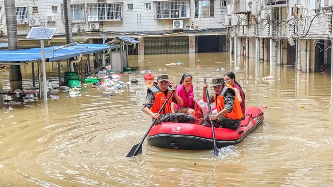 Paramilitary police officers evacuate residents in a rubber dinghy through a flooded area after rainfall brought by typhoon Maysak, in Nanning, Guangxi Zhuang Autonomous Region, China July 6, 2026. cnsphoto via REUTERS