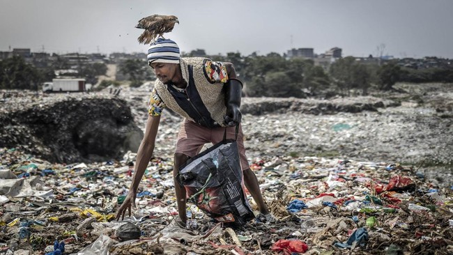 Rodgers Oloo Magutha, 28, popularly known as Nairobi Birdman, carries a Black Kite on his head while working as a plastic waste collector at a dumpsite in Kayole, a low-income neighbourhood on the outskirts of Nairobi, on July 4, 2026. Once a homeles