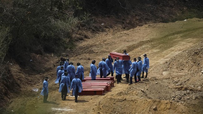 Workers carry a coffin of an earthquake victim, next to other coffins at La Esperanza Cemetery in the aftermath of the June 24 earthquakes, in La Guaira, Venezuela, July 6, 2026. REUTERS/Adriano Machado     TPX IMAGES OF THE DAY