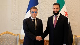 Syria's President Ahmed al-Sharaa (R) shakes hands with France's President Emmanuel Macron ahead of their meeting at the People's Palace in Damascus on July 7, 2026. Syria's President Ahmed al-Sharaa hailed France's "constructive role" in the transit