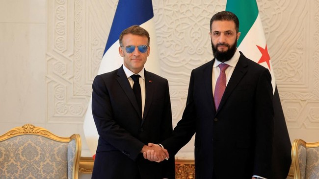 Syria's President Ahmed al-Sharaa (R) shakes hands with France's President Emmanuel Macron ahead of their meeting at the People's Palace in Damascus on July 7, 2026. Syria's President Ahmed al-Sharaa hailed France's 