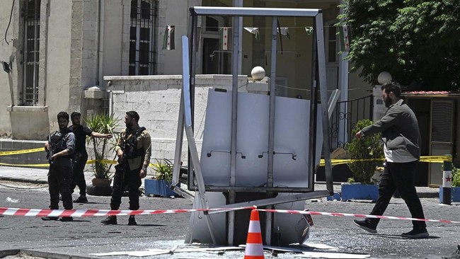 Security personnel stand guard near the Four Seasons Hotel following two blasts nearby in Damascus on July 7, 2026. Two explosions shook Damascus on July 7 near a hotel where French President Emmanuel Macron was staying, wounding at least 18 people,