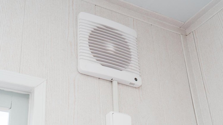 The photo of the fan on a white wall for air circulation